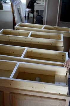 a man standing in front of wooden drawers