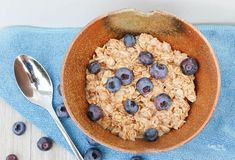 a bowl filled with oatmeal and blueberries on top of a towel