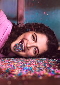 a woman laying on top of a bed covered in sprinkles with her eyes closed