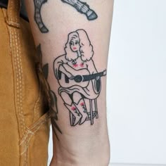 a man with a tattoo on his arm holding a guitar