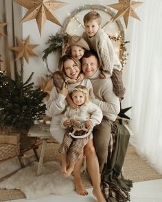 a group of people sitting on top of a chair in front of a christmas tree