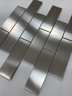 stainless steel tiles on a white table with no one in them or the tile is shiny