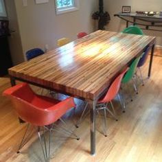 a wooden table with colorful chairs around it