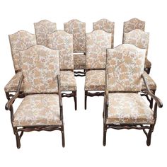 a set of eight chairs with floral upholstered back and armrests,