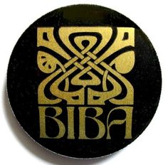 a black and gold button with the word biba on it