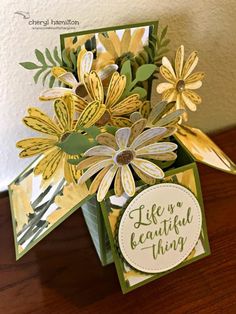 a close up of a card on a table with some flowers in it and the words life is beautiful thing