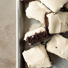 a pan filled with brownies covered in white frosting