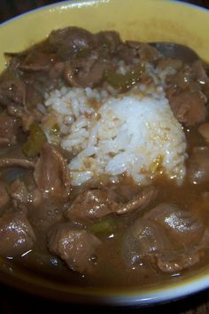 a yellow bowl filled with meat and rice