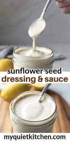 two jars filled with white sauce sitting on top of a wooden cutting board