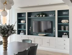 a dining room table and chairs with built in entertainment center