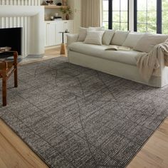 a living room with a white couch and wooden floors