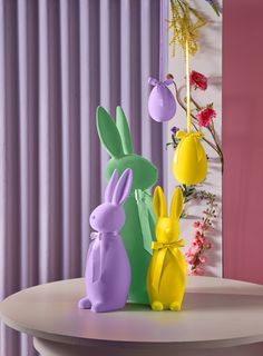 three plastic easter bunnies sitting on top of a table