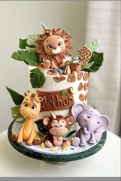 a three tiered cake decorated with animals and giraffes