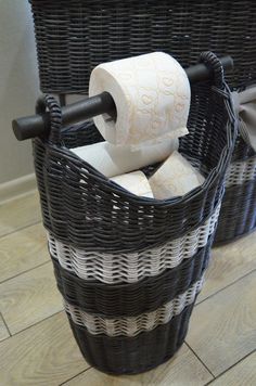 two wicker baskets with toilet paper in them on the floor next to each other