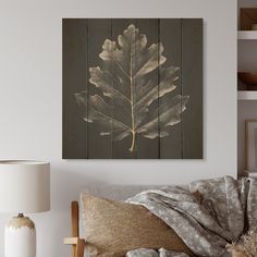 a large leaf is hanging on the wall above a bed