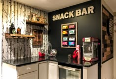 a small kitchen with black and white wallpaper on the walls, including a snack bar