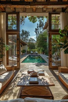 a living room with couches and tables near a pool