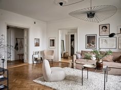 a living room filled with furniture and pictures on the wall