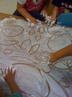 two children are making an art project with plastic wrap