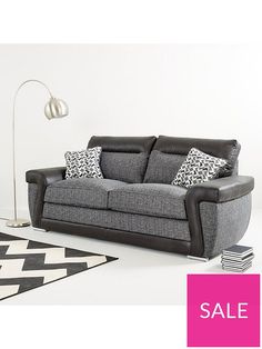 a living room with a gray couch and black and white rugs on the floor