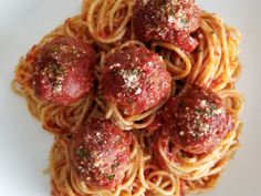 spaghetti with meatballs and parmesan cheese on top, ready to be eaten