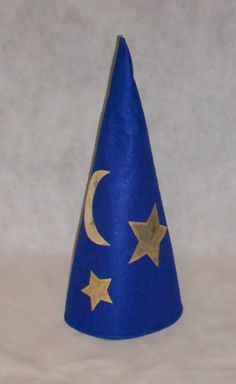 a small blue cone with gold stars and crescent on it's side, sitting on a white surface