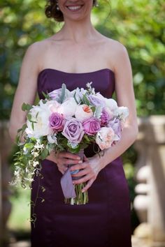 a woman in a purple dress holding a bouquet