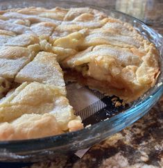 a pie sitting on top of a table next to a glass bowl filled with pie crust