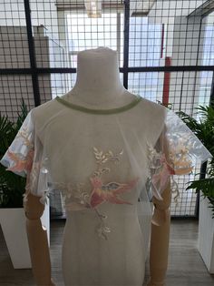 a mannequin wearing a sheer top with flowers on it