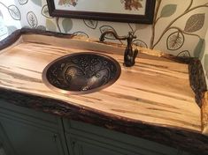 a bathroom sink made out of wood and metal faucet on top of a counter