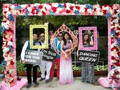 a group of people standing in front of a decorated arch with signs reading i came to sing queen and dancing for the beer