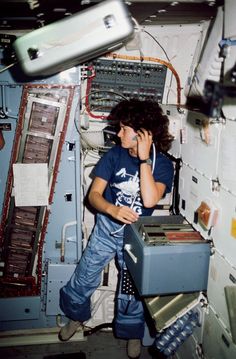 a young man talking on a cell phone while standing in front of a space station