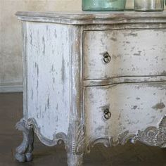 an old white dresser with drawers and knobs on the bottom, is featured in this post