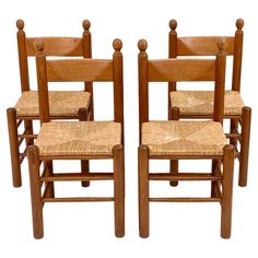 four wooden chairs sitting side by side on a white background