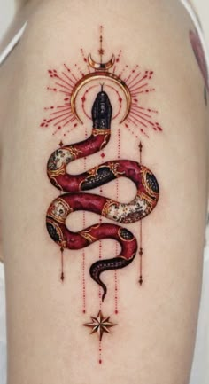 a woman's thigh with a snake and sun tattoo on the back of her leg