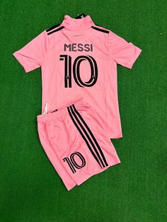 a pink soccer uniform with black numbers on the front and bottom, sitting on green grass