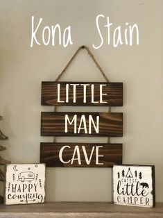 two wooden signs that say little man cave and kona stain on the wall behind them