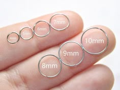 three sizes of rings are shown in the palm of someone's hand, with measurements for each ring