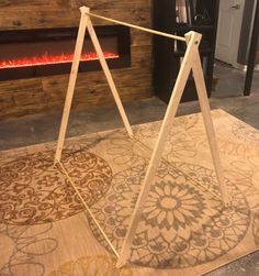 a wooden frame sitting on top of a rug in front of a fireplace