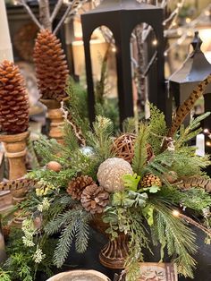 a christmas centerpiece with pine cones and greenery