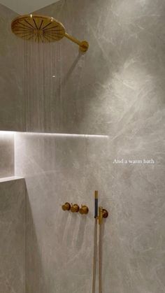 a shower head and hand shower in a bathroom with white marble tiles on the walls