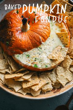 an orange is sitting on top of chips in a bowl with the words baked pumpkin fondue