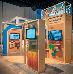 an exhibit booth with multiple displays on the wall and in front of it is a large screen