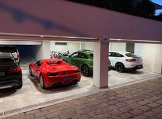 three cars are parked in a garage with their doors open and one car is on the other side