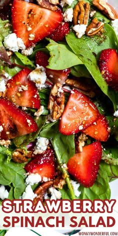 strawberry spinach salad with pecans and goat cheese on top, served in a white bowl