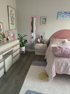 a bedroom with pink and white furniture and decor