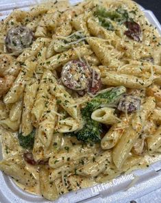 a plastic container filled with pasta and broccoli