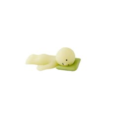 a small plastic toy with a white body and green head laying on it's side