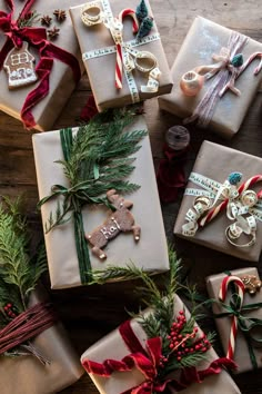 christmas presents wrapped in brown paper and tied with red ribbon on top of a wooden table