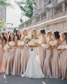 a group of bridesmaids standing together in front of a building